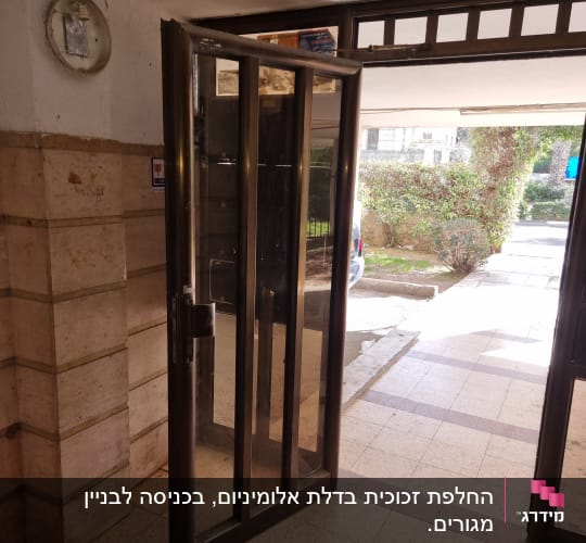 דלת זכוכית עם מסגרת מתכת בכניסה לבניין